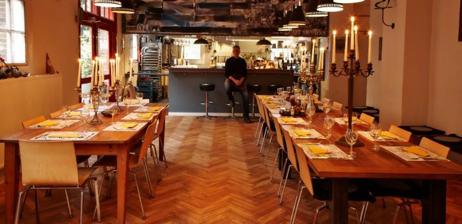 Tables laid in the studio, candlelight and open kitchen