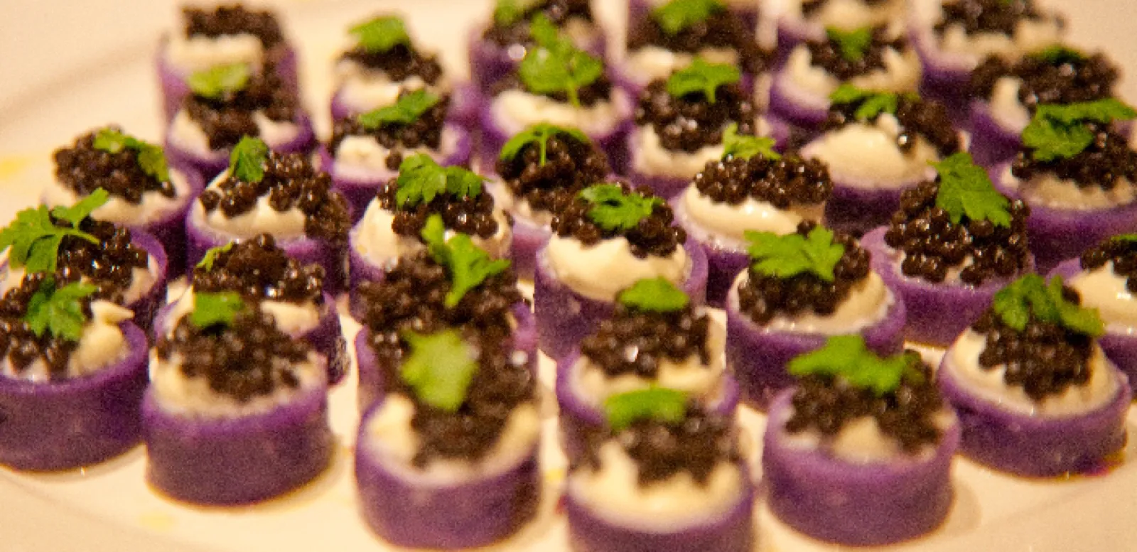 Purple potato bites with cream and caviar